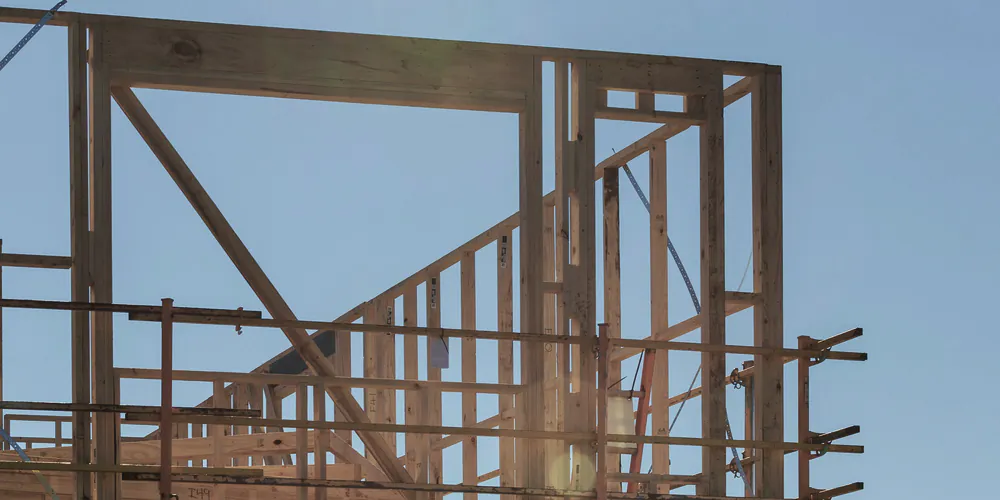 The timber frame of an upper floor against the sky