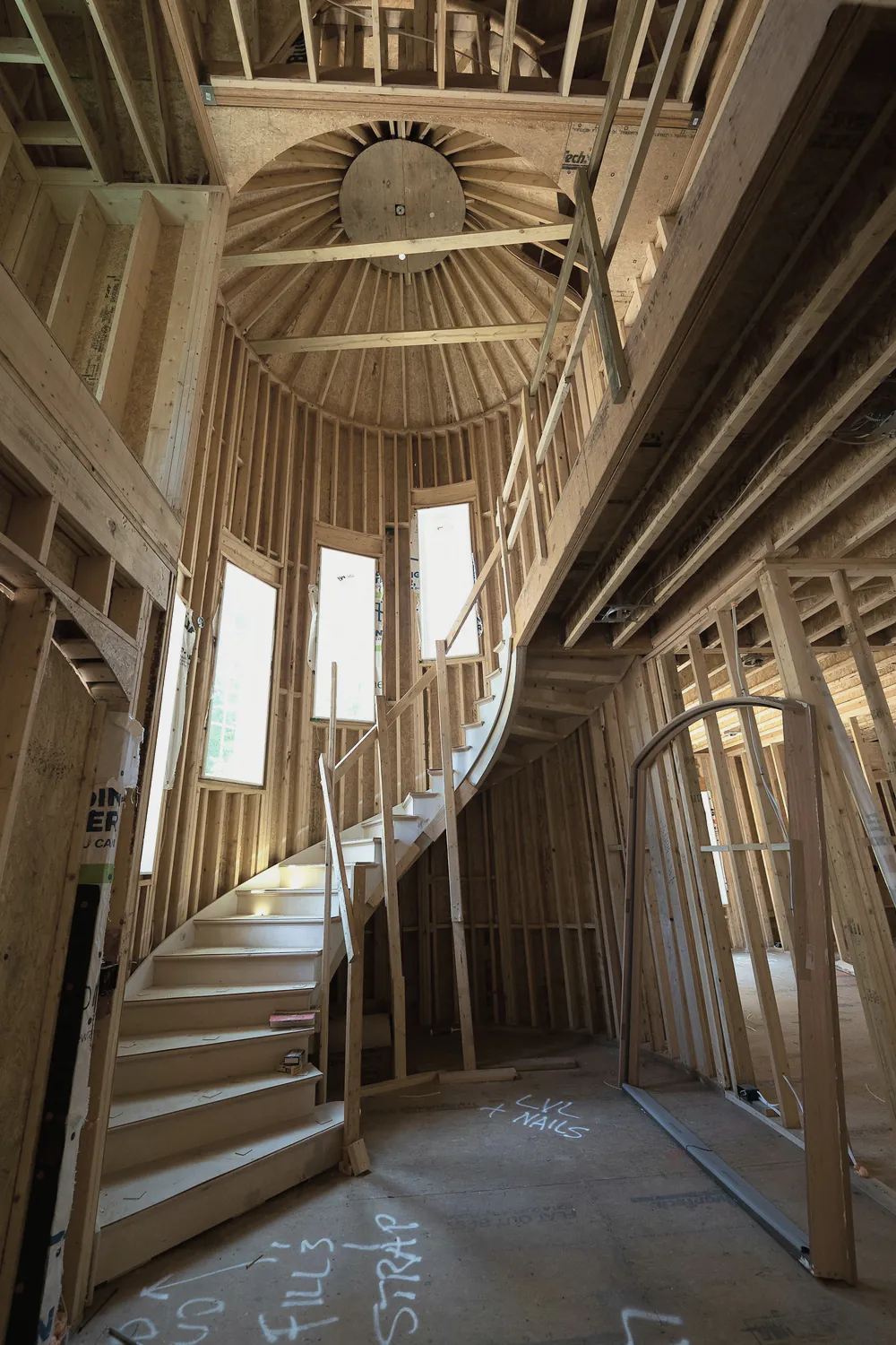 A curved timber stair inside a house frame