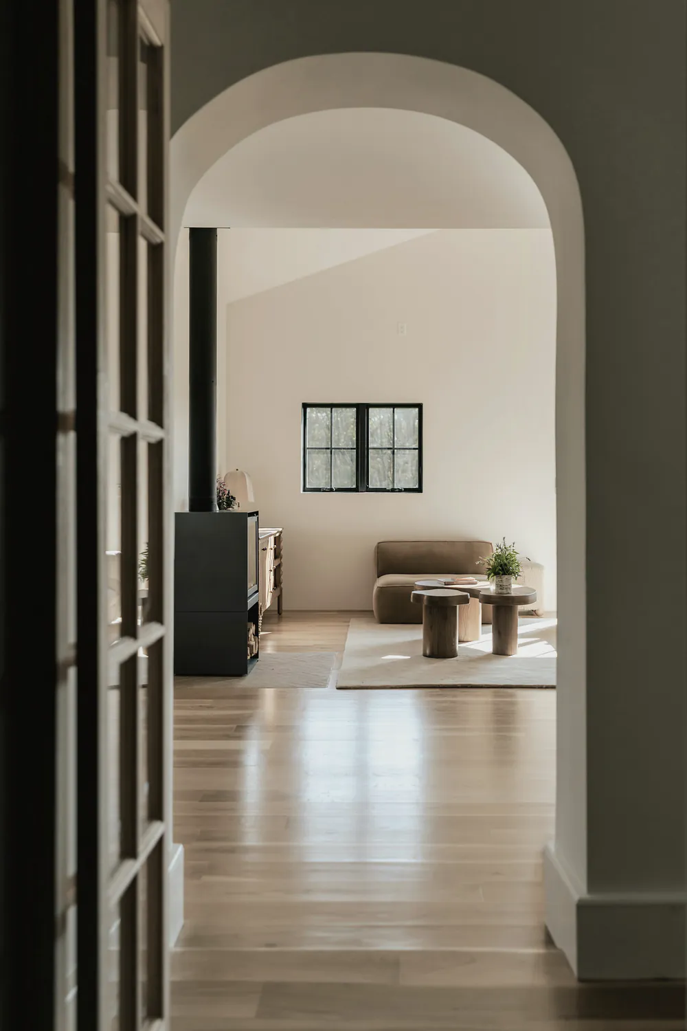 A lime plaster archway opening from a hall into a light living room