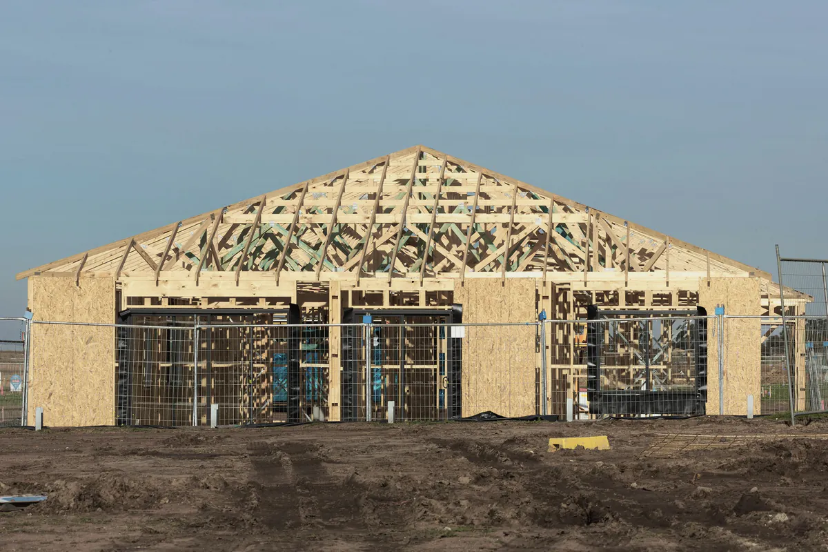 A house at frame stage with its roof trusses up